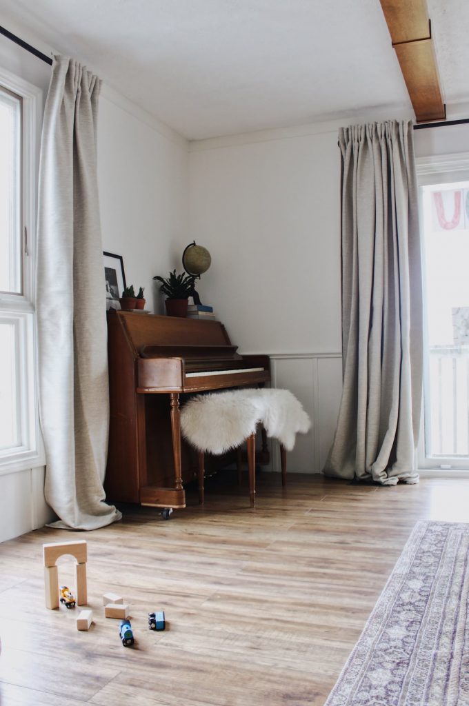 living room with piano and extra long curtain rods